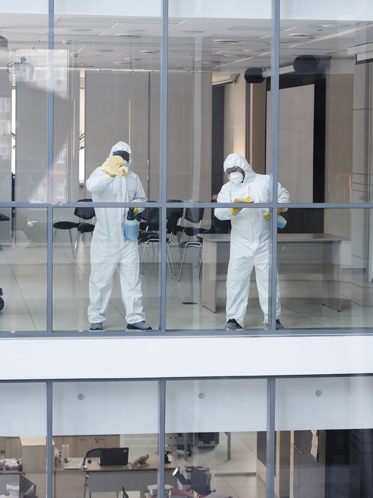 Deux techniciens désinfectant des bureaux professionnels